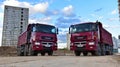 Red dump trucks KAMAZ-65801-002-68ÃÂ¢5 8Ãâ¦4 on construction site for transportation of bulk cargo.